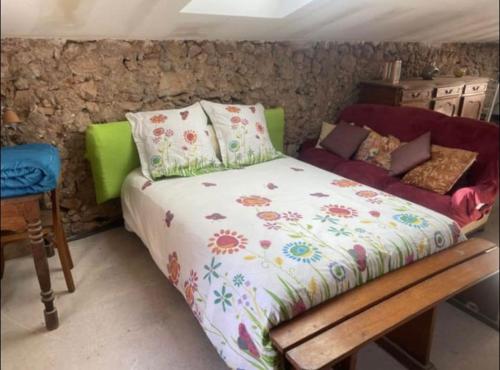 a bed in a room with a stone wall at RELAIS EQUESTRE DE LA CHEVALIERE SAUVAGE in Tourves