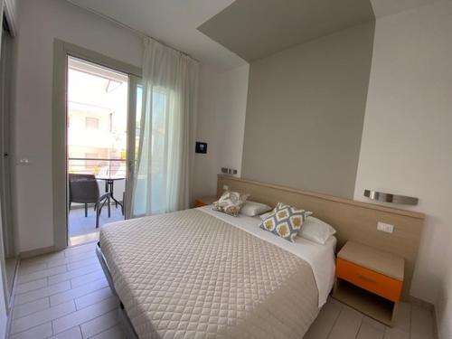 a bedroom with a large bed and a large window at Residenza Viel in Bibione