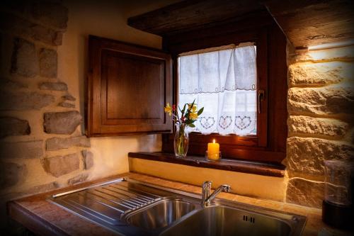 a kitchen with a sink and a window with a vase of flowers at Canto del Fiume in Ortignano Raggiolo