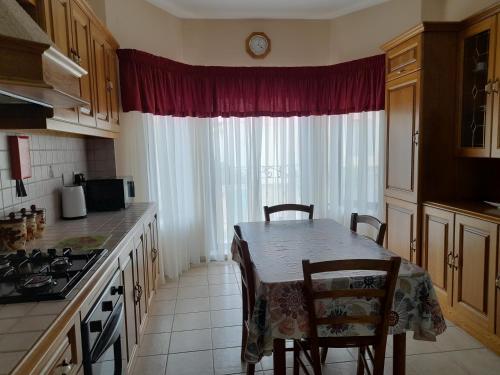 a kitchen with a table and chairs and a window at Silver Shadow Holiday Maisonette in Marsaxlokk