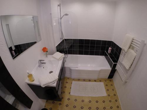 a bathroom with a tub and a sink and a mirror at Maison Carles BnB in La Colle-sur-Loup