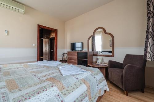 貝凱什喬包的住宿－全景酒店，一间卧室配有一张床、一把椅子和镜子