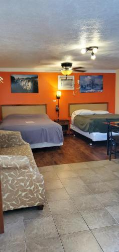 a hotel room with two beds and a couch at Sunparlor Motel in Leamington