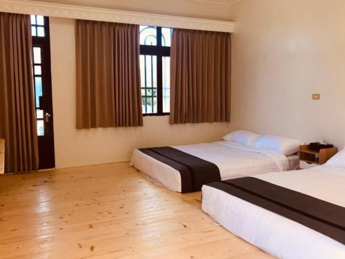 Starry Sky Hostel في تشيتشينج: غرفة فندقية بسريرين ونوافذ