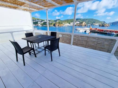 een tafel en stoelen op een terras met uitzicht op het water bij Maridea - La Darsena in Ponza