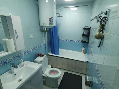 a bathroom with a sink and a toilet and a mirror at Guest house Homely in Dushanbe