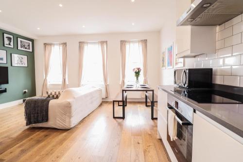 a living room with a couch and a kitchen at Modern & spacious 1 bedroom Clapham Junction flat in London