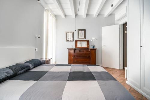 ein Schlafzimmer mit einem großen Bett und einer Holzkommode in der Unterkunft L'Atelier del Centro: tra design, storia e fascino in Brescia