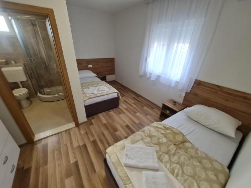 a small room with two beds and a bathroom at Pansion Vesna&Vlado Ostojic in Međugorje