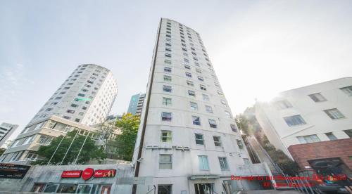 a tall white building with two tall white buildings at Columbia Apartments in Auckland