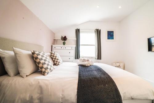 ein Schlafzimmer mit einem großen weißen Bett mit Kissen in der Unterkunft Modern & spacious 1 bedroom Clapham Junction flat in London