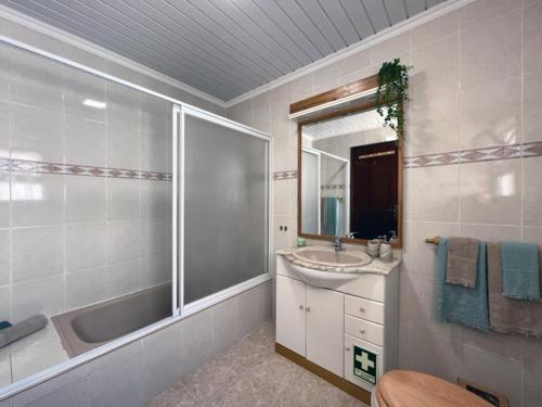 ein Bad mit einer Badewanne, einem Waschbecken und einer Dusche in der Unterkunft Casa Mar in Ponta Delgada