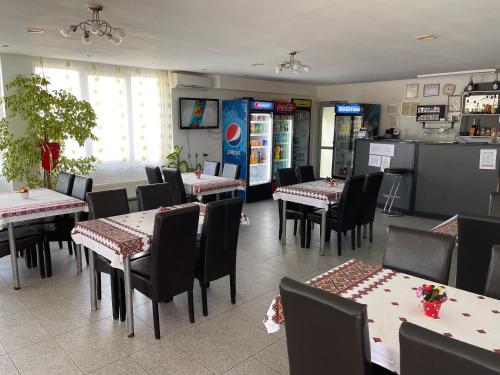 une salle à manger avec des tables et des chaises dans un restaurant dans l'établissement Pensiunea Simina, à Caransebeş