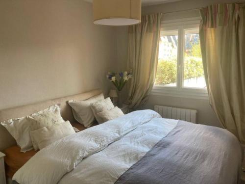 een slaapkamer met een groot bed met witte lakens en kussens bij TOP central Cabourg double terrasse 80m2 MER in Cabourg