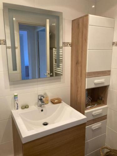 une salle de bain avec un lavabo blanc et un miroir dans l'établissement TOP central Cabourg double terrasse 80m2 MER, à Cabourg