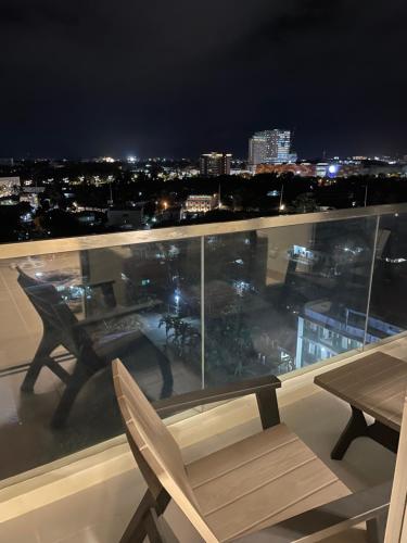 a table and chairs on a balcony at night at S & E Condo with Panoramic View in Iloilo City