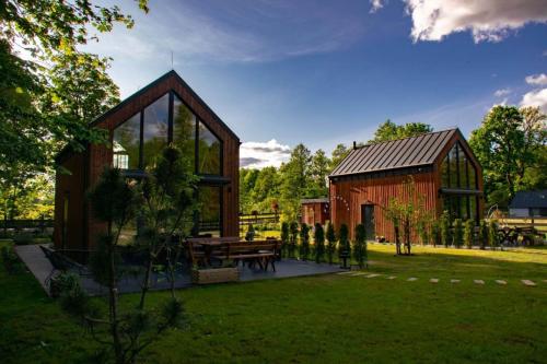 a wooden pavilion with a picnic table and a barn at Zielone Wrzosowisko in Świętajno