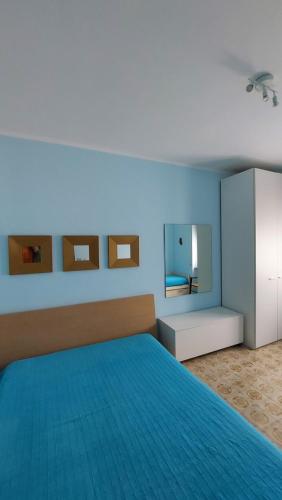 Dormitorio azul con cama y espejo en Appartamento vicino al mare a Scalea, en Scalea