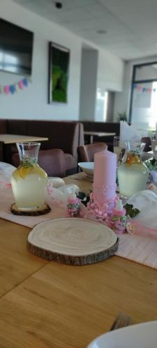 a wooden table with two candles and flowers on it at Relaxcentrum Ľudmila in Cabaj-Čápor