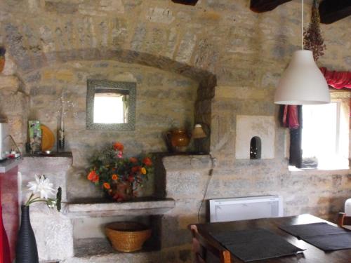 een keuken met een tafel en een stenen muur bij Gîte La Veyrie in Cazals