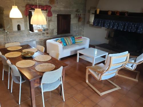 een woonkamer met een tafel en stoelen en een bank bij Gîte La Veyrie in Cazals