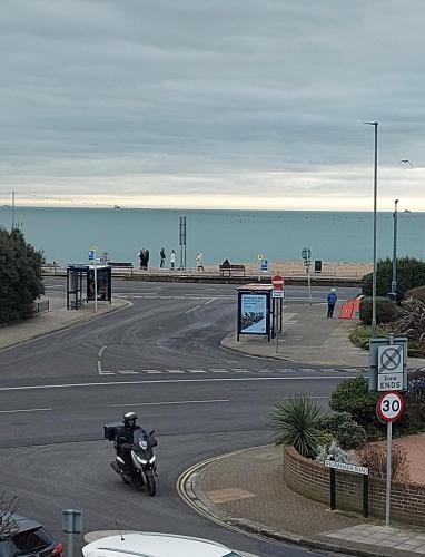 a person riding a motorcycle on a road near the beach at Inn By The Sea, PORTSMOUTH in Portsmouth