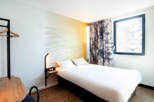 Un pat sau paturi într-o cameră la B&B HOTEL Cluses Sud