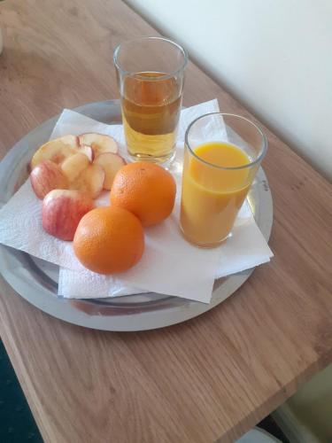 un plato de fruta y dos vasos de zumo de naranja en Edwards Cosy B&B, en Galway