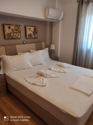 Astradeni luxury apartments Vootis في Páloi: غرفة نوم عليها سرير وفوط