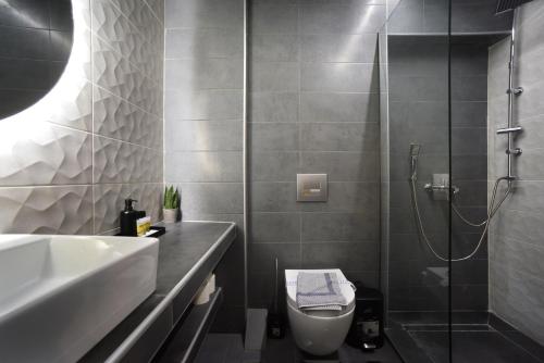 a bathroom with a shower and a toilet and a sink at Porto Boutique #B in Thessaloniki