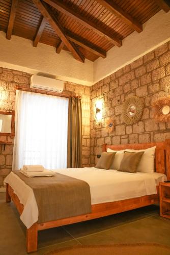 a bedroom with a large bed with a window at Armi Alaçatı in Cesme