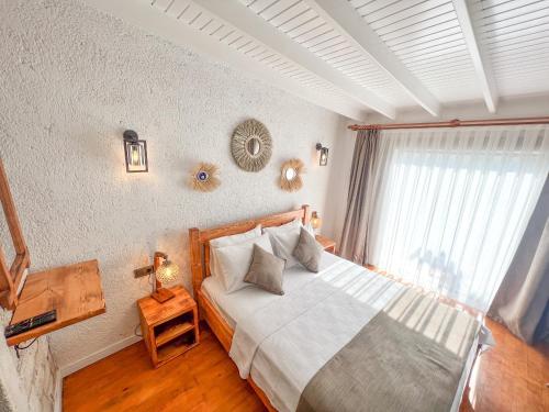 a bedroom with a large bed and a window at Armi Alaçatı in Cesme