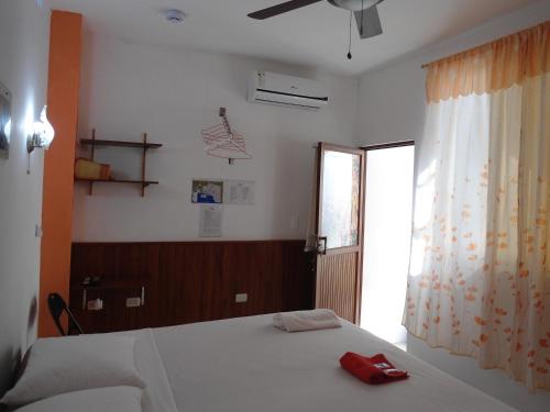 a bedroom with a bed with a red phone on it at Sun Island in Puerto Villamil