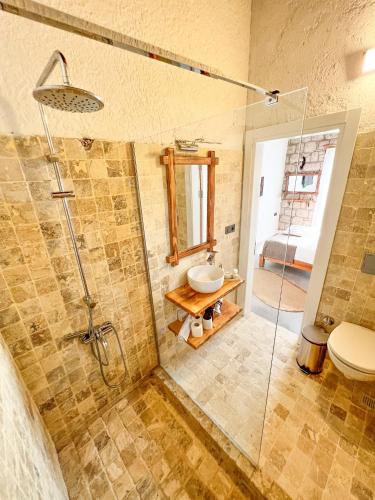 a bathroom with a shower and a sink and a toilet at Armi Alaçatı in Cesme