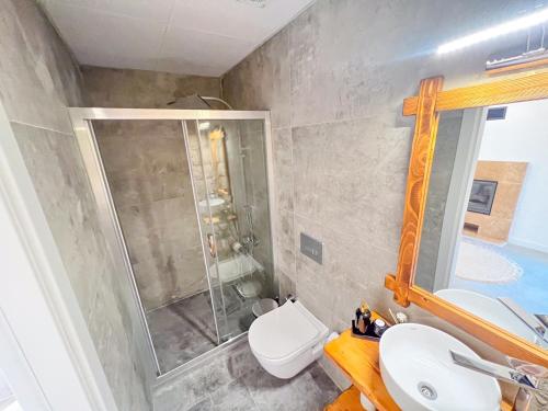 a bathroom with a shower and a toilet and a sink at Armi Alaçatı in Cesme