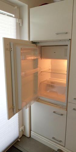 an empty refrigerator with its door open in a kitchen at Ferienwohnung in Grenzach in Grenzach-Wyhlen