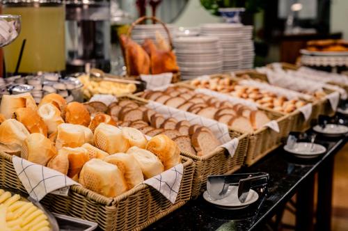 a buffet with several baskets of bread and pastries at Hotel Dan Inn Planalto São Paulo in Sao Paulo