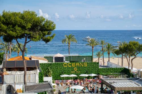 uma vista para uma praia com palmeiras e para o oceano em Coconut Apartments - Adults Only em Magaluf