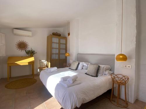 um quarto com uma grande cama branca com toalhas em Romantic Ronda garden cottage em Ronda