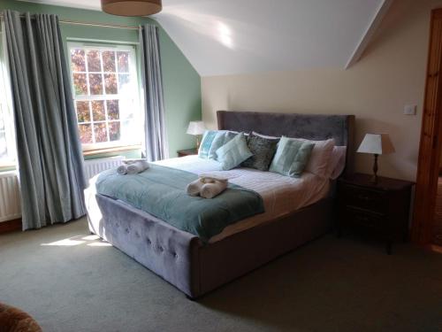 a bedroom with a bed with two stuffed animals on it at Tullynacrunat Lodge in Castleblayney