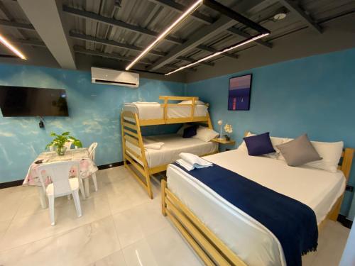 a bedroom with two beds and a table and a bunk bed at AL HAMRA in San Andrés