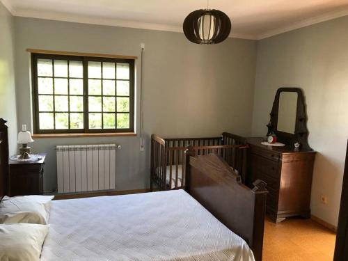 1 dormitorio con cama, tocador y espejo en Duplex em casa inteiro. 4 quartos. Bem localizada., en Bragança