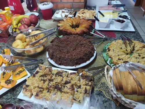 een tafel met veel verschillende soorten voedsel bij Recanto Paraíso Aventuras in Rio Negrinho