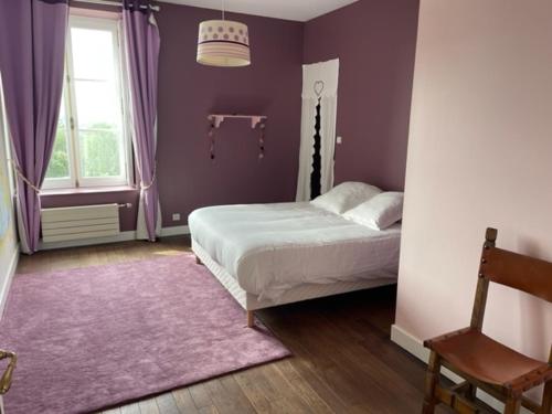 - une chambre avec un lit et un mur violet dans l'établissement Le Logis Cholet 49300 lieu exceptionnel en famille ou amis, à Mazières-en-Mauges