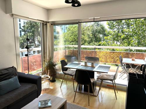 un salon avec une table et une grande fenêtre dans l'établissement LA BAULE : T2 TRÈS PROCHE MER AU CALME, à La Baule