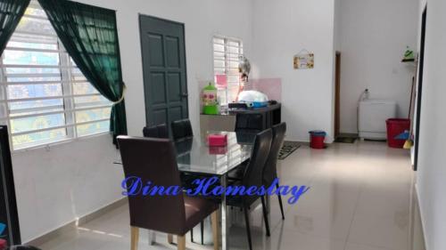 una sala da pranzo con tavolo in vetro e sedie di Dina Homestay B a Pasir Puteh