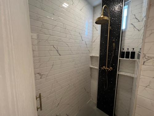 a bathroom with a shower with a white brick wall at Villa PaSon in Khao Kho