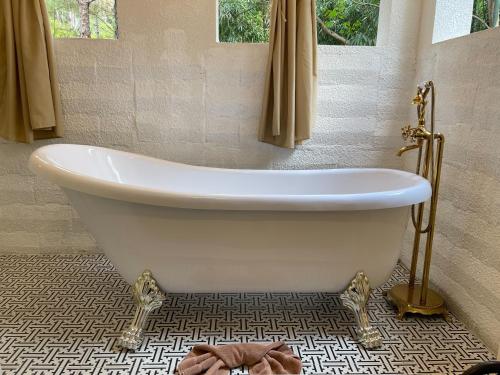 a white bath tub in a bathroom with a tile floor at Villa PaSon in Khao Kho