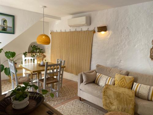 een woonkamer met een bank en een tafel bij Romantic Ronda garden cottage in Ronda