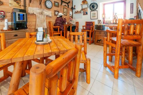 uma sala de jantar com uma mesa de madeira e cadeiras em Hotel Le Ranch em Brûlon